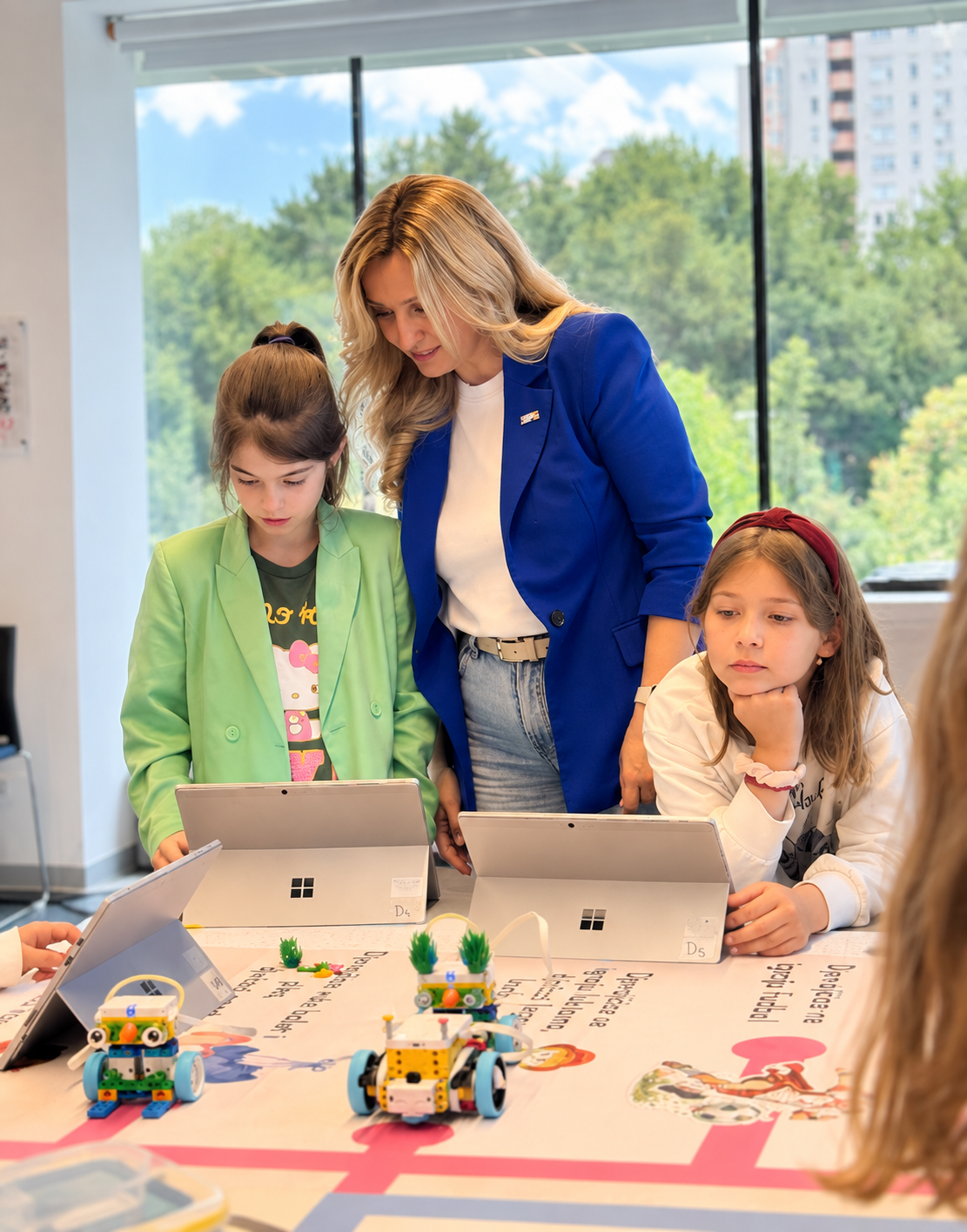Majka i ćerke programiraju LEGO robote na posebno izrađenoj mapi radionice o stereotipima.