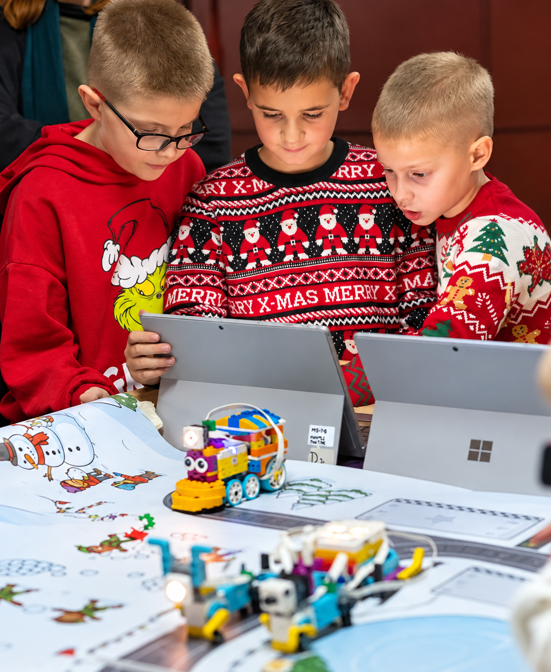 Djeca istražuju LEGO robote na prazničnoj tematskoj mapi.